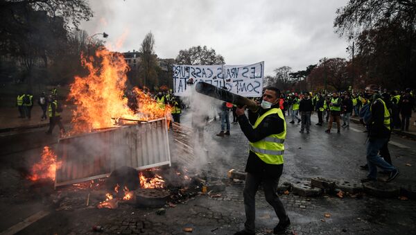 Manifestantes construir uma barricada durante um protesto de coletes amarelos (Gilets jaunes) contra o aumento dos preços do petróleo e os custos de vida, em 1 de dezembro de 2018 em Paris. - Sputnik Brasil