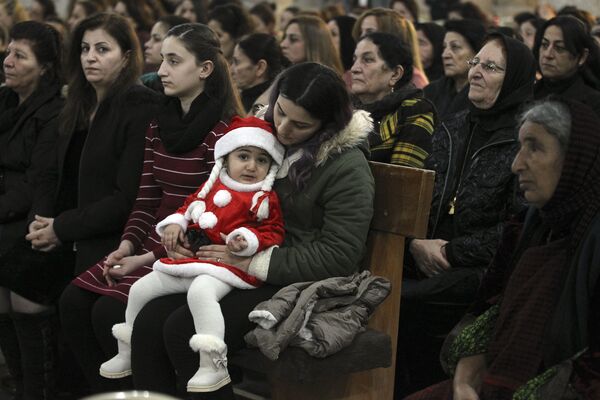 Cristãos iraquianos assistem à missa na véspera de Natal, na cidade predominantemente cristã de Qaraqosh, a cerca de 30 quilômetros de Mosul, Iraque, em 24 de dezembro de 2018 - Sputnik Brasil
