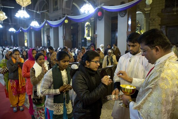 Padre distribui hóstia durante missa da meia-noite de Natal em Allahabad, Índia, 25 de dezembro de 2018 - Sputnik Brasil
