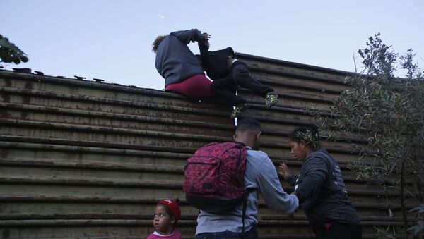 Migrantes hondurenhos ajudam-se mutuamente a atravessar fronteira dos EUA até San Diego, Califórnia. - Sputnik Brasil