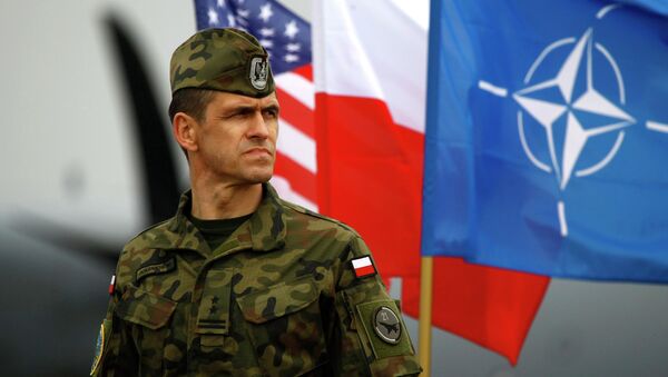 Soldado polonês junto às bandeiras da OTAN, Polônia e EUA - Sputnik Brasil