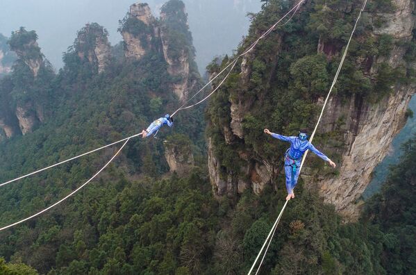Dois participantes, vestidos como personagens do filme Avatar, durante a competição de Slackline nas montanhas Yuantszyatsze no centro da Província de Hunan, na China - Sputnik Brasil