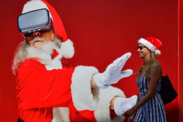 Garota passa por um pôster gigante do Papai Noel em Dubai - Sputnik Brasil