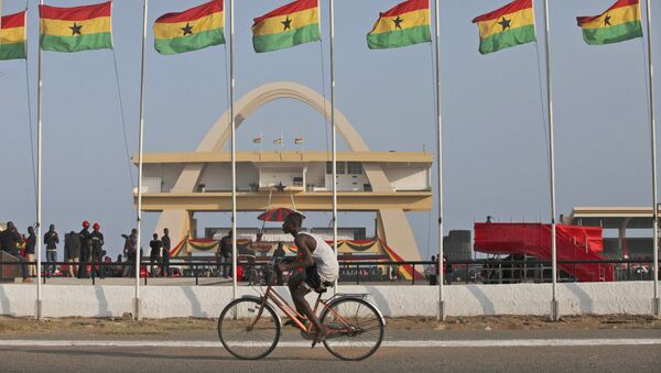 Homem andando de bicicleta ao lado de bandeiras de honra ao presidente de Gana, John Evans Atta Mills, na Praça da Independência em Acra, Gana, 9 agosto de 2012 (foto do arquivo) - Sputnik Brasil