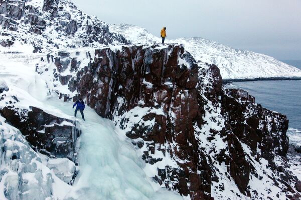 Turista no topo de uma cachoeira congelada da península de Kola (extremo norte da Rússia) - Sputnik Brasil