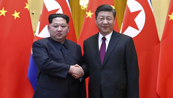 O líder norte-coreano Kim Jong Un e o presidente chinês Xi Jinping apertam as mãos em Pequim, na China. - Sputnik Brasil