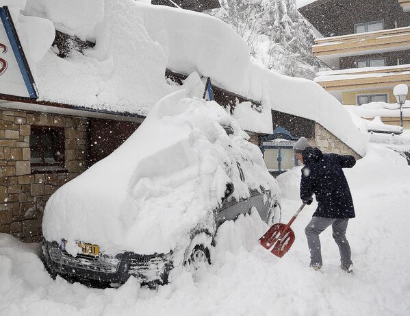 Um homem remove a neve do seu carro em Filzmoos, Áustria - Sputnik Brasil