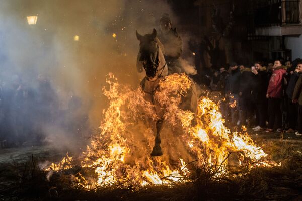 Cavaleiro passando pelo fogo durante o festival anual Las Luminarias na cidade espanhola de San Bartolomé de Pinares - Sputnik Brasil