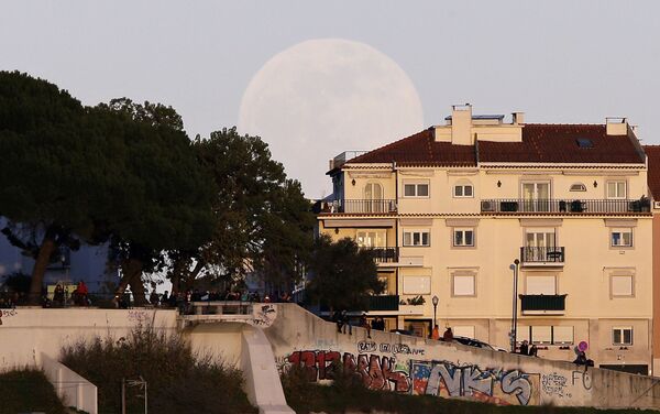 Pessoas assistem ao pôr do sol do topo de uma colina enquanto a lua cheia se eleva por atrás, 20 de janeiro de 2019, em Lisboa, Portugal - Sputnik Brasil