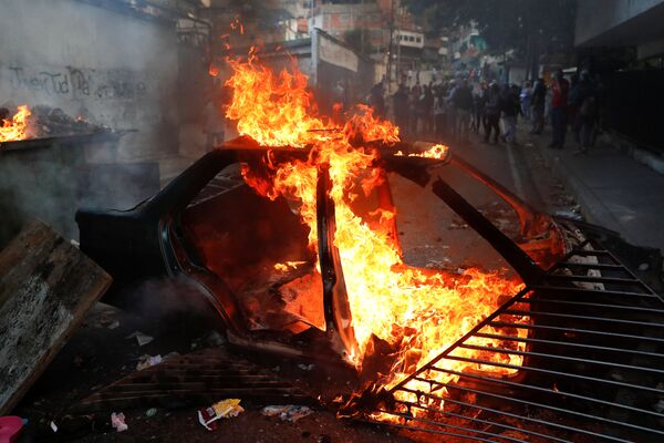 Carro em chamas durante protestos em Caracas, Venezuela - Sputnik Brasil