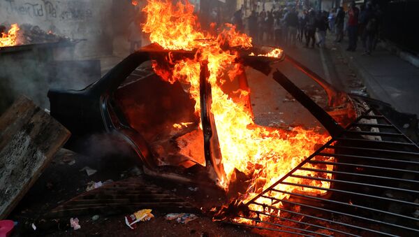 Carro em chamas durante protestos em Caracas, Venezuela - Sputnik Brasil