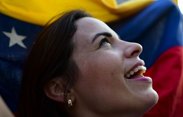 Mulher segura bandeira venezuelana durante manifestação contra o presidente venezuelano, Nicolás Maduro - Sputnik Brasil