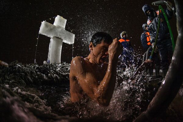 Homem durante o banho tradicional da festa da Epifania na Rússia - Sputnik Brasil