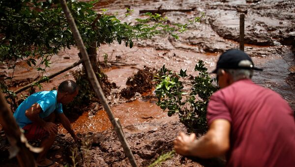 Moradores trabalham em um rio coberto por lama após uma barragem pertencente à mineradora brasileira Vale SA explodir em Brumadinho, Brasil, em 26 de janeiro de 2019. - Sputnik Brasil