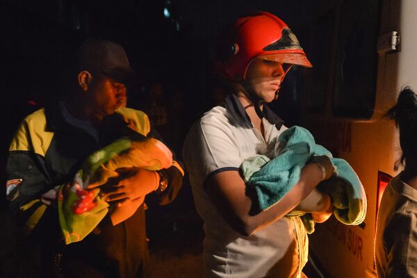 Bombeiros cubanos seguram bebês embrulhados em cobertores durante a evacuação - Sputnik Brasil