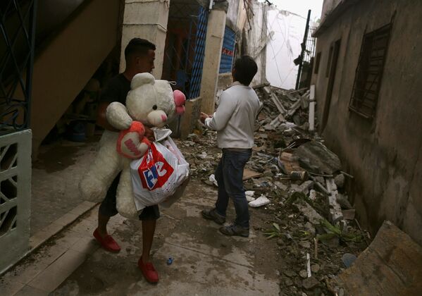 Homem segura bens nas ruas destruídas depois do tornado na capital de Cuba - Sputnik Brasil