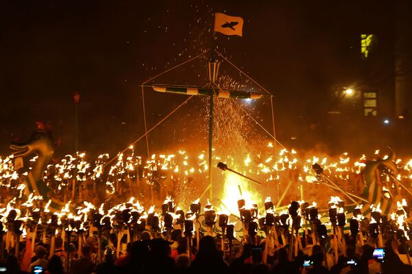 Portadores de tochas, ou Guizers, vestidos de vikings, incendeiam navio enquanto participam do festival Up Helly Aa, na Escócia - Sputnik Brasil