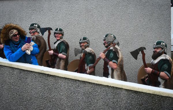 Mulher fotografa participantes vestidos de vikings enquanto se preparam para desfilar pelas ruas de Lerwick, na Escócia, 29 de janeiro de 2019 - Sputnik Brasil