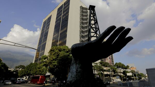 Escultura de uma mão segurando uma bomba de óleo atrás da sede da empresa venezuelana PDVSA em Caracas - Sputnik Brasil
