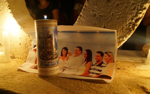 Família é vista em foto colocada sob uma vela no memorial criado por moradores na entrada de Brumadinho, MG. - Sputnik Brasil