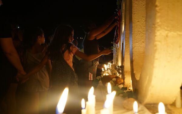 Uma criança é vista acendendo uma vela no letreiro de Brumadinho, local que se converteu em memorial em homenagem aos mortos pelo rompimento de barragem da Vale. - Sputnik Brasil