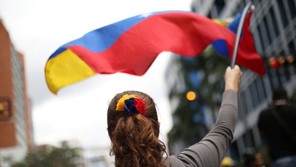 Uma manifestante venezuelana com a bandeira nacional - Sputnik Brasil