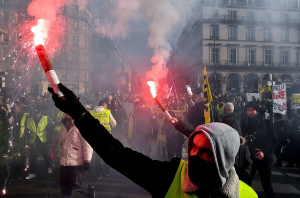 Manifestantes queimam sinalizadores enquanto participam de greve para exigir melhores salários e pensões em Paris, na França - Sputnik Brasil