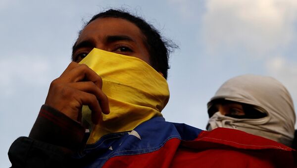 Manifestantes durante um protesto contra o governo do presidente venezuelano Nicolas Maduro em Caracas. - Sputnik Brasil