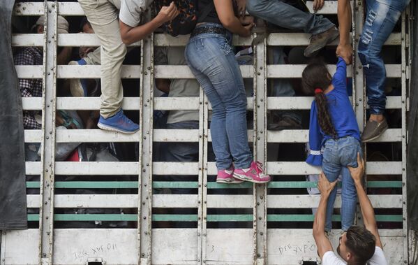 Migrantes venezuelanos sobem em caminhão na estrada de Cucuta para Pamplona, na Colômbia, em 10 de fevereiro de 2019 - Sputnik Brasil