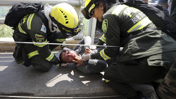 Paramédicos colombianos resgatam venezuelana ferida na Ponte Símon Bolívar, na fronteira entre Colômbia e Venezuela. - Sputnik Brasil