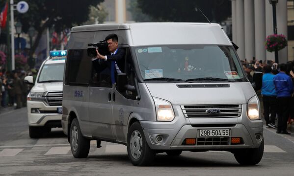 Operador de câmera norte-coreano filma a deslocação de Kim Jong-un pela capital vietnamita, em 26 de fevereiro de 2019 - Sputnik Brasil