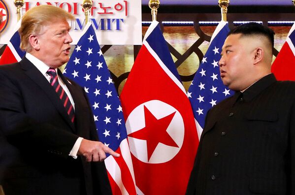O presidente dos EUA Donald Trump fala com o líder norte-coreano Kim Jong-un depois de os dois líderes apertarem as mãos durante sua segunda reunião, em Hanói - Sputnik Brasil