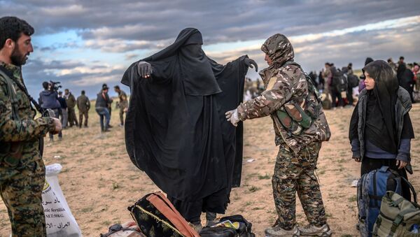 Membro das Forças Democráticas da Síria (SDF), lideradas por curdos, revista mulher em Baghouz, no norte da Síria, em 27 de fevereiro de 2019 - Sputnik Brasil