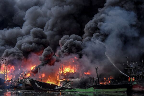 Bombeiros tentam apagar fogo, que está queimando barcos de pesca no porto de Muara Baru, em Jacarta, Indonésia, 23 de fevereiro de 2019 - Sputnik Brasil