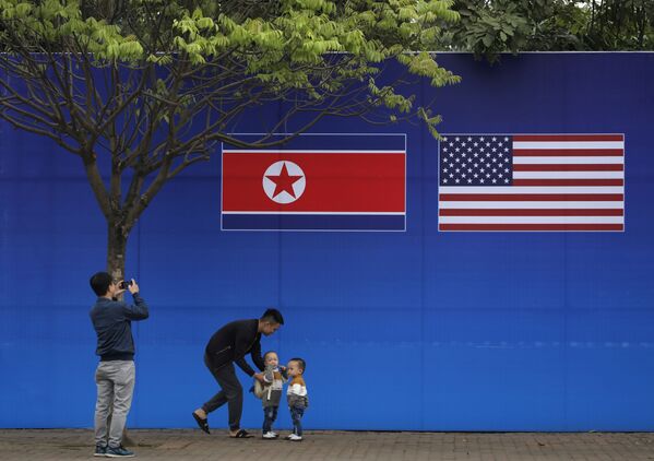 Pessoas tiram fotos em frente à bandeira da Coreia do Norte e dos EUA, em Hanói, Vietnã, 24 de fevereiro de 2019 - Sputnik Brasil