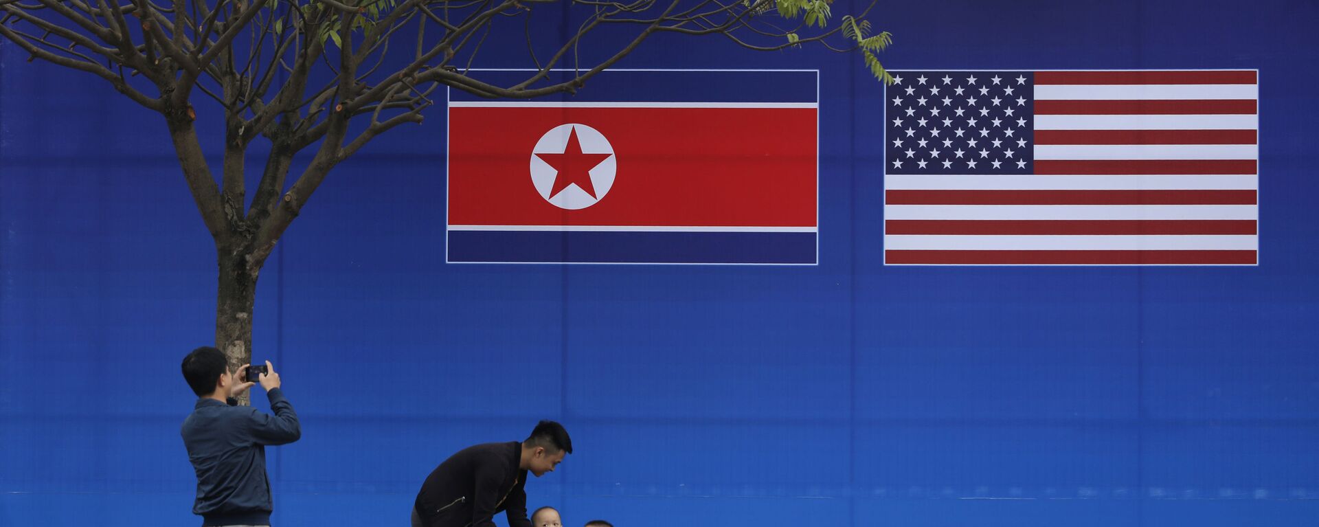 Pessoas tiram fotos em frente à bandeira da Coreia do Norte e dos EUA, em Hanói, Vietnã, 24 de fevereiro de 2019 - Sputnik Brasil, 1920, 05.06.2023