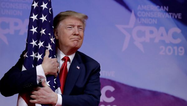 Presidente dos EUA, Donald Trump, abraça bandeira americana na reunião anual da Conferência da Ação Política Conservadora (CPAC), perto de Washington, EUA, em 2 de março de 2019 - Sputnik Brasil