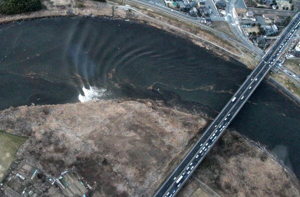 Foto aérea mostra ondas de tsunami movendo-se na cidade de Hitachinaka, na província japonesa de Ibaraki, 11 de março de 2011 - Sputnik Brasil