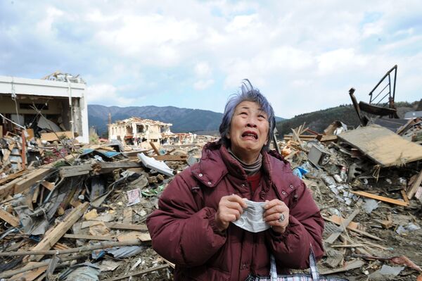 Idosa chora em frente a um prédio destruído na devastada cidade de Rikuzentakata, na província japonesa de Iwate, 19 de março de 2011 - Sputnik Brasil