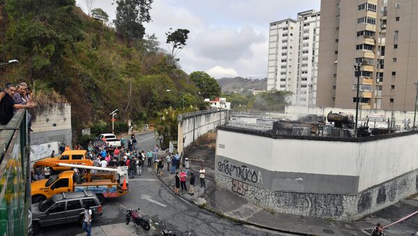 Moradores de Caracas reunidos do lado de fora de uma subestação de energia danificada da estatal Corpoelec, na capital do país, onde explosões de causa desconhecida ocorreram neste 11 de março de 2019, dias após o início de um grande apagão elétrico que segue afetando várias áreas da Venezuela. - Sputnik Brasil