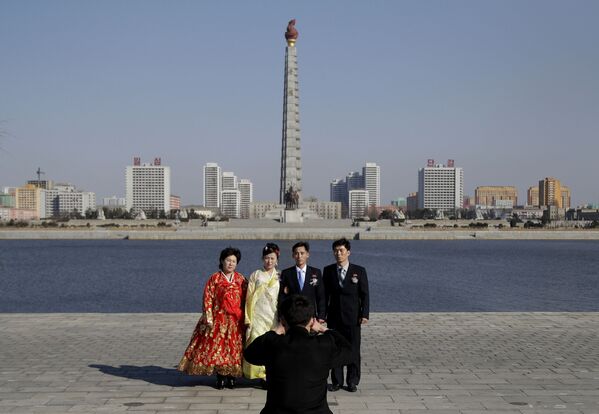 Uma família posa para foto de casamento em frente da Torre da Ideologia Juche, Pyongyang - Sputnik Brasil