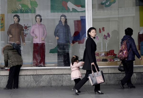 Norte-coreanas passam pela vitrina de uma loja no centro de Pyongyang - Sputnik Brasil