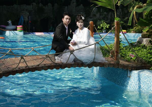 Recém-casados posam para foto em uma piscina coberta em Pyongyang - Sputnik Brasil