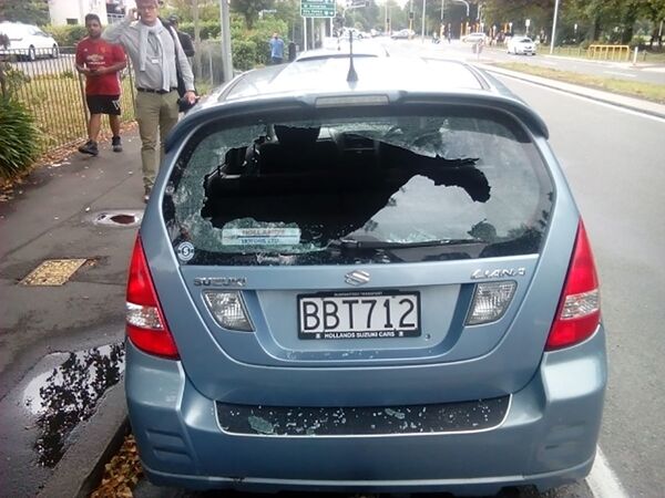 Um homem telefona ao lado de um carro com janelas estilhaçadas perto da mesquita Al Noor depois do tiroteio na cidade neozelandesa de Christchurch - Sputnik Brasil