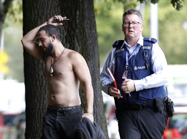Um homem e um policial perto da mesquita Al Noor após o tiroteio na cidade de Christchurch - Sputnik Brasil