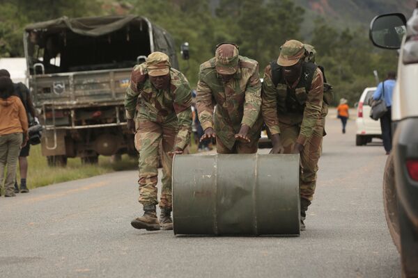 Soldados de Zimbabué empurram barril de combustível usado para operações de resgate na região de Chimanimani, Zimbabué - Sputnik Brasil