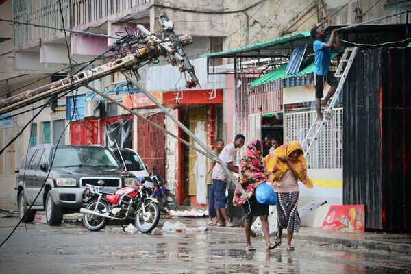 Moradores locais estão tentando se proteger da chuva após a passagem do ciclone tropical Idai, cidade de Beira, Moçambique - Sputnik Brasil