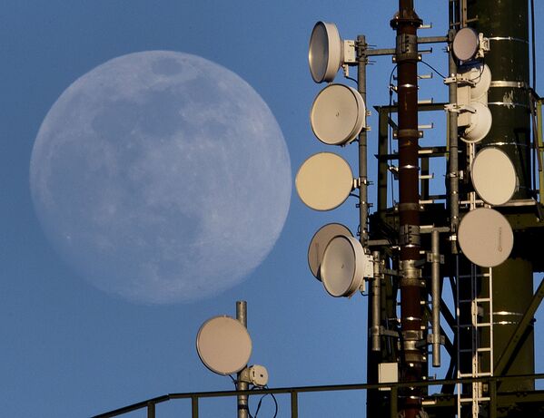 A Lua cheia se levantando por trás de uma torre de rádio no distrito alemão de Wachenbuchen, perto de Frankfurt - Sputnik Brasil