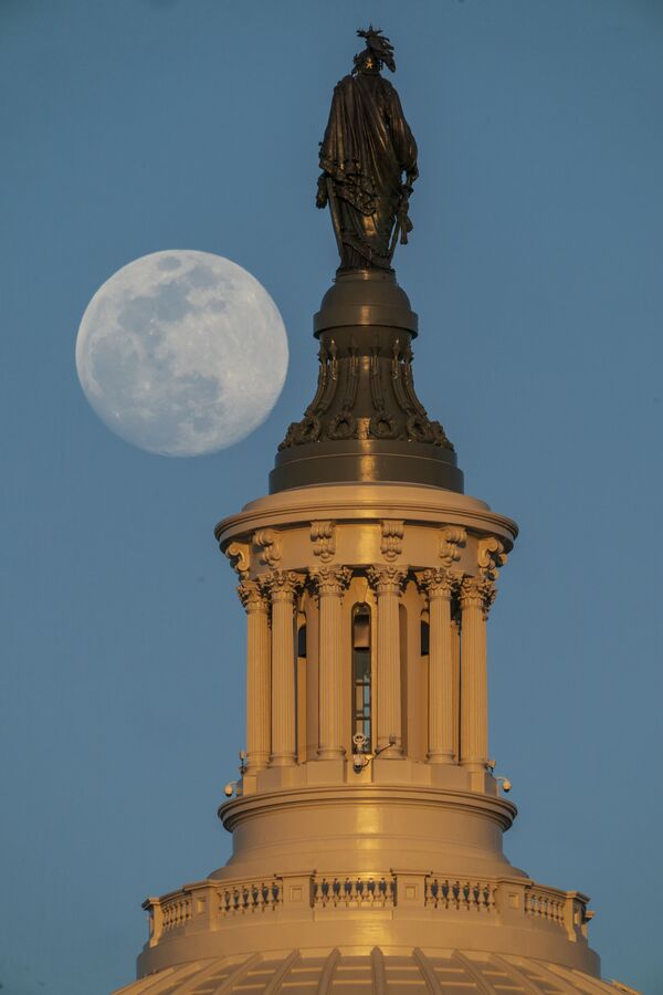 A Lua cheia captada à esquerda da Estátua da Liberdade, no cimo do Capitólio dos Estados Unidos, em Washington, D.C - Sputnik Brasil