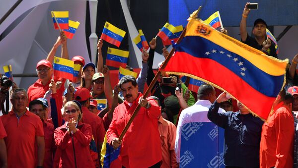 O presidente venezuelano Nicolás Maduro agita a bandeira nacional durante uma marcha pró-governamental em Caracas, em 23 de fevereiro de 2019. - Sputnik Brasil